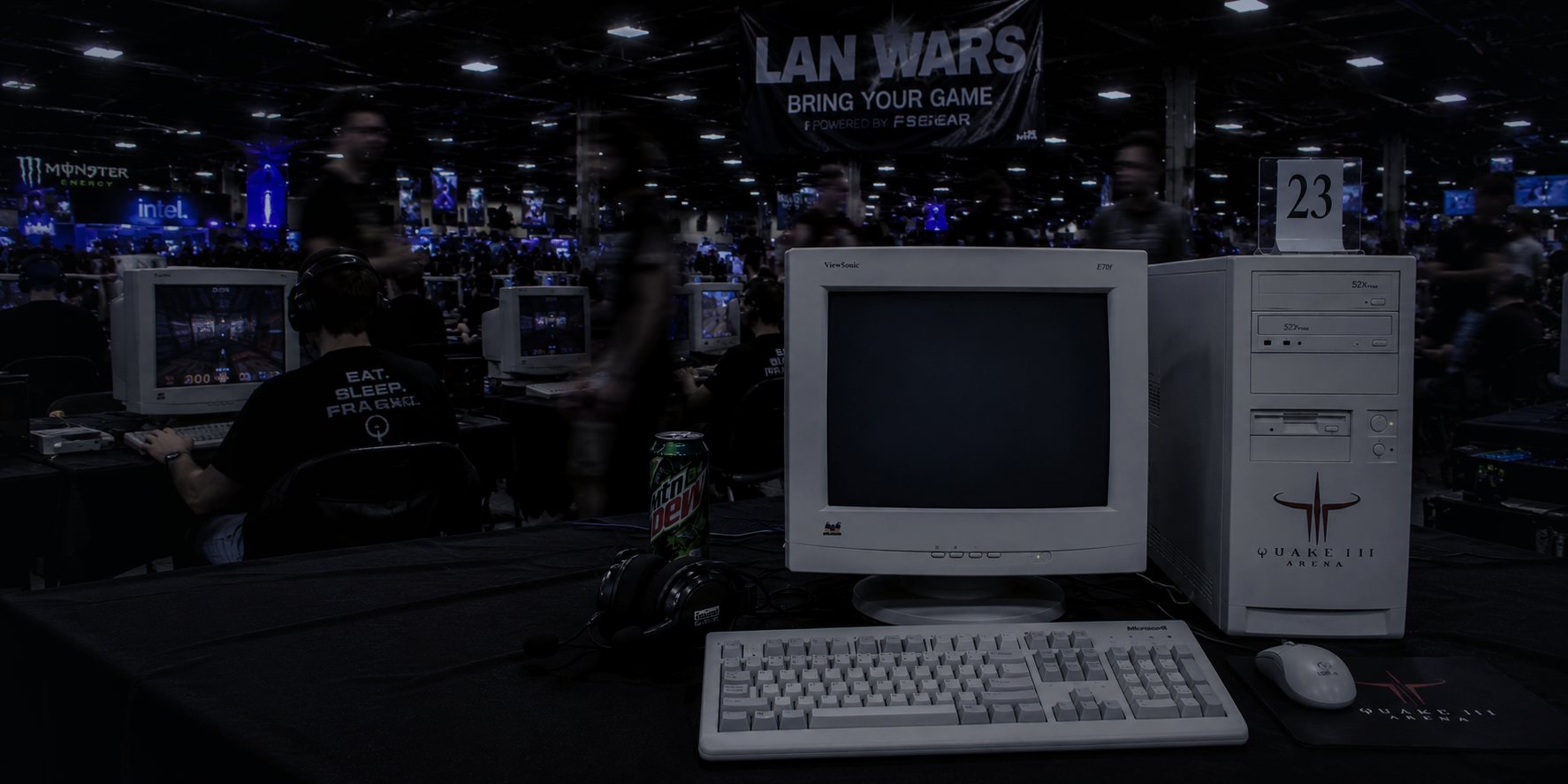 A LAN tournament hall — vintage CRT monitor and Quake III Arena tower at seat 23